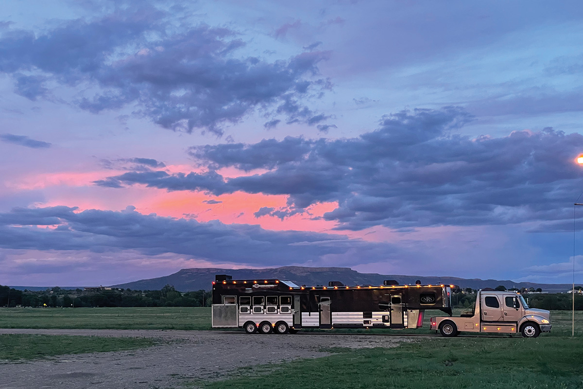 A large rig sits in front of a mountain sunset