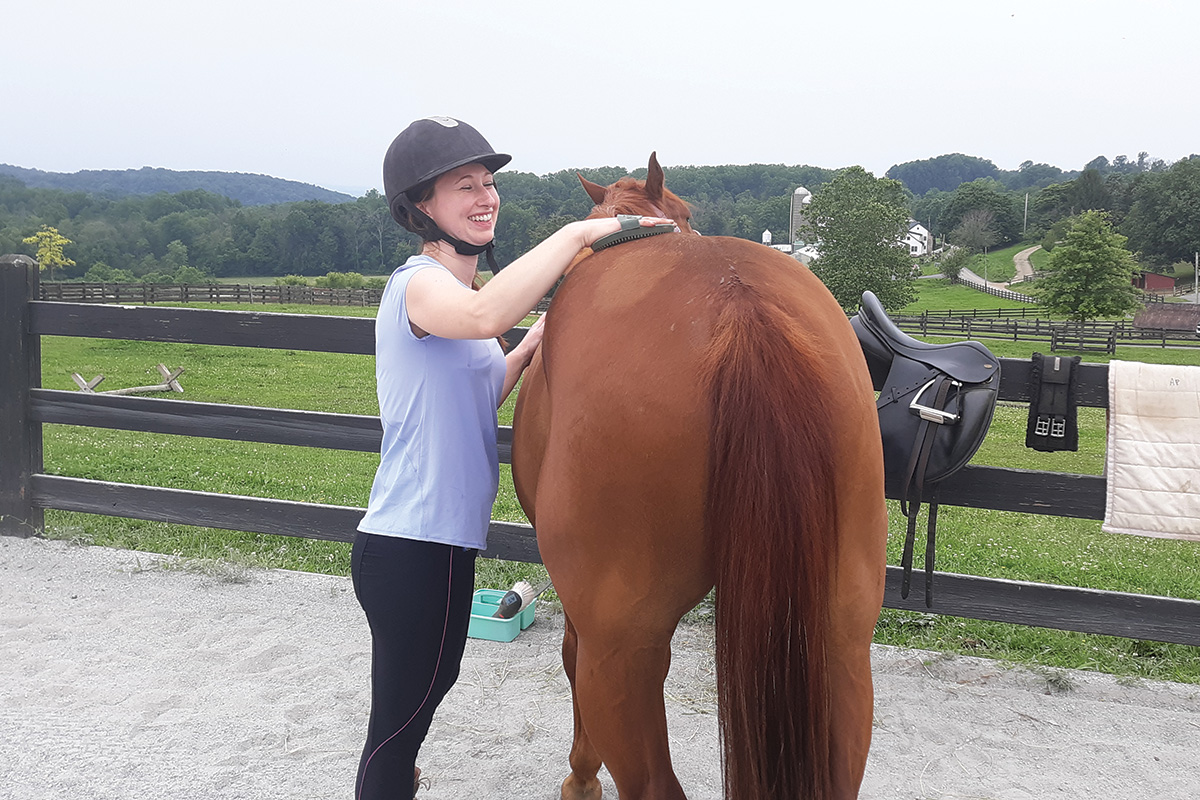 Body, Mind, Equine retreat participant practices mindful grooming with a horse