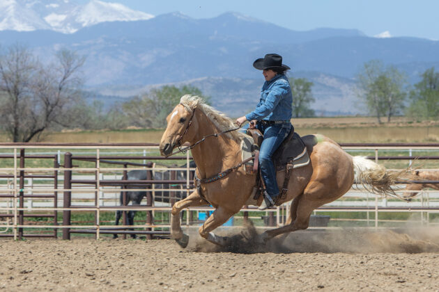 A cowgirl practicing a barrel racing pattern without a barrel