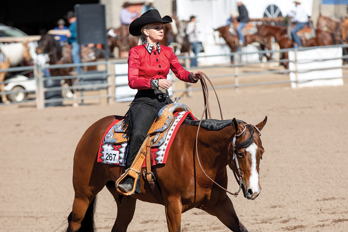 A rider shows her horse in western riding, keeping her breathing steady to calm horse show anxiety and nerves