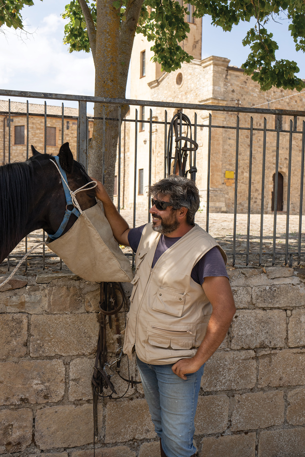 The guide feeds one of the horses with a sack