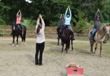 Riders practicing the Temple Pose at a yoga and horsemanship retreat