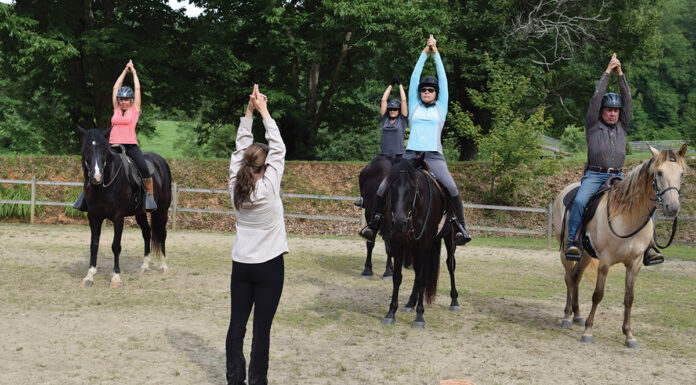 Riders practicing the Temple Pose at a yoga and horsemanship retreat