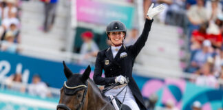 Jessica von Bredow-Werndl (GER) waves to the crowd after her gold-clinching test aboard TSF Dalera BB in the Dressage Team Final at the Paris 2024 Olympic Games in equestrian dressage