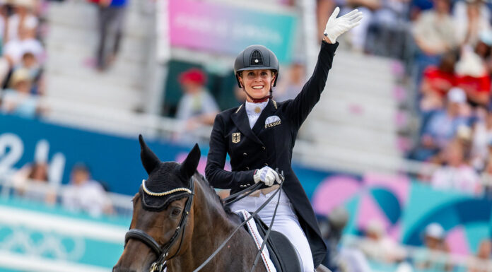 Jessica von Bredow-Werndl (GER) waves to the crowd after her gold-clinching test aboard TSF Dalera BB in the Dressage Team Final at the Paris 2024 Olympic Games in equestrian dressage