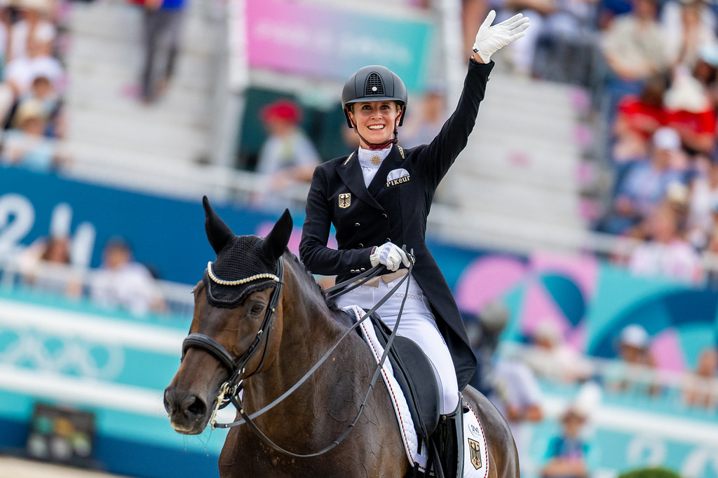 Jessica von Bredow-Werndl (GER) waves to the crowd after her gold-clinching test aboard TSF Dalera BB in the Dressage Team Final at the 2024 Paris Olympics