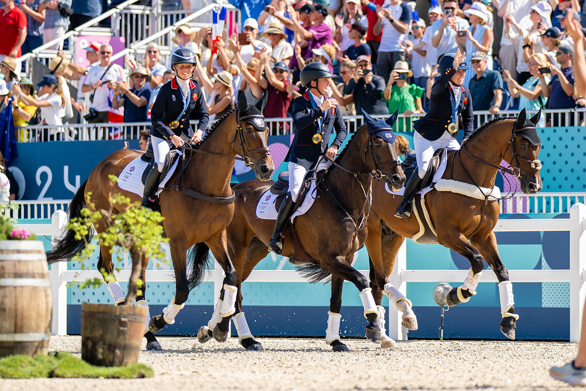 The Great Britain Eventing Team takes a victory lap around the stadium after winning gold in eventing at the 2024 Paris Olympics