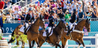 The Great Britain Eventing Team takes a victory lap around the stadium after winning gold in eventing at the 2024 Paris Olympics