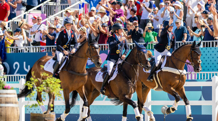 The Great Britain Eventing Team takes a victory lap around the stadium after winning gold in eventing at the 2024 Paris Olympics