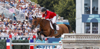 Karl Cook and Caracole de la Roque go clear during the Team Show Jumping Final at the 2024 Paris Olympics for the USA