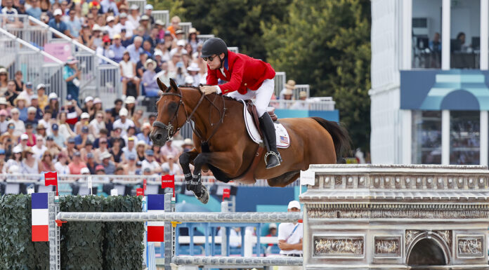 Karl Cook and Caracole de la Roque go clear during the Team Show Jumping Final at the 2024 Paris Olympics for the USA