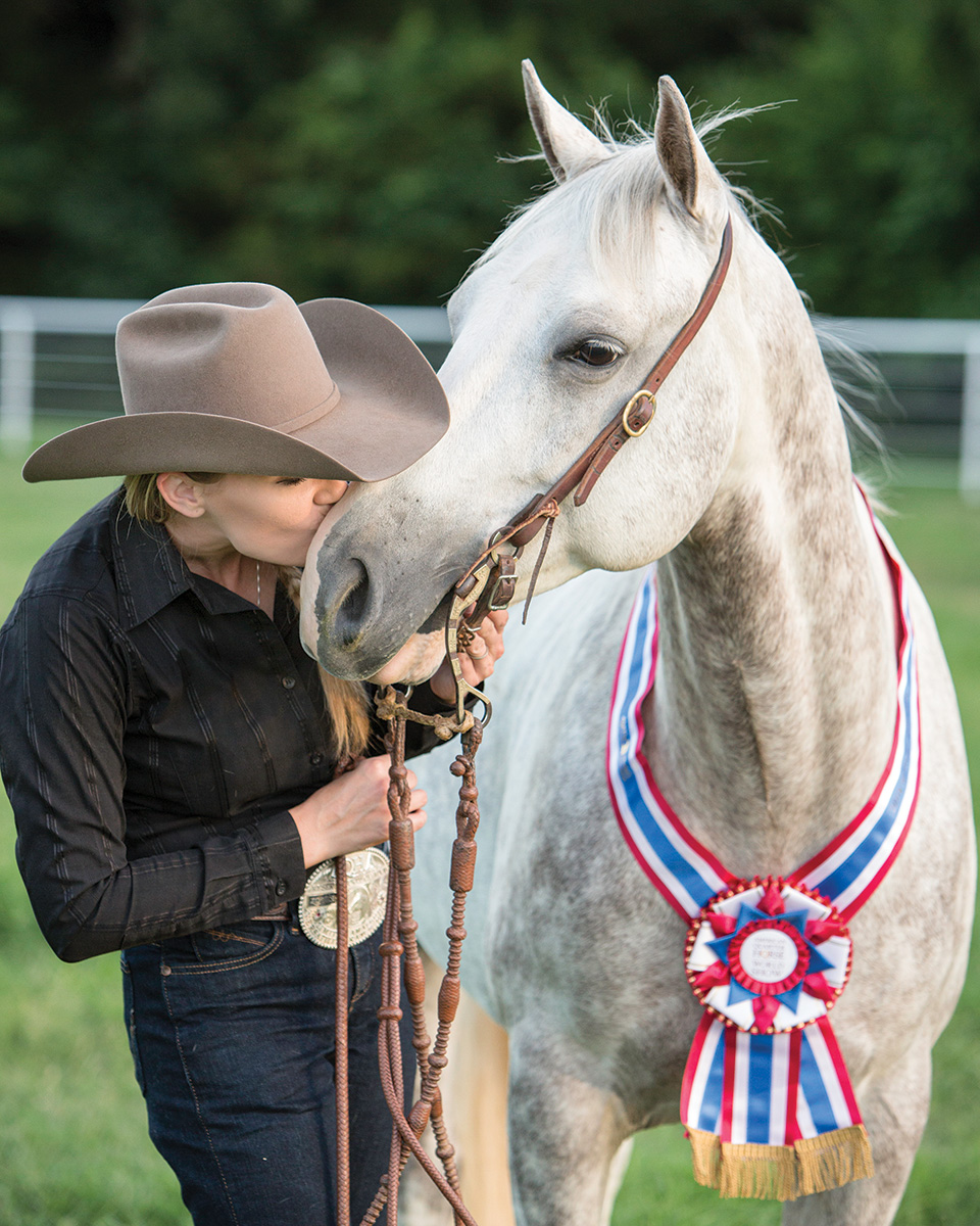 A portrait of Jessica Rumbaugh and Boonfull Of Caesar with their championship ribbon