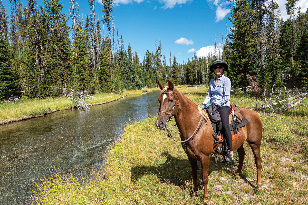 Trail riding near a river while horse camping