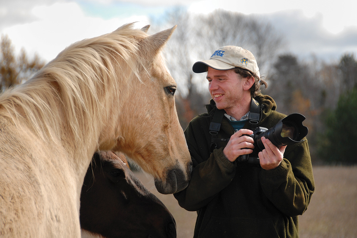 A man with a camera, learning the new skill of equine photography as a winter activity when there is less time for riding.