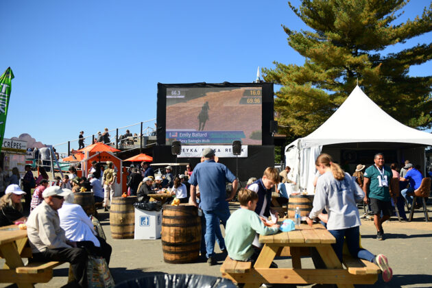 A big screen television with livestreaming of the Maryland 5 Star looms over the dining area in the trade fair