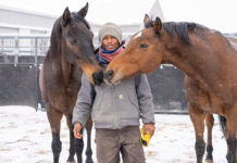 Colorado-based dressage trainer Nahshon Cook with two horses in the snow. Cook is a proponent of trauma-informed horsemanship.