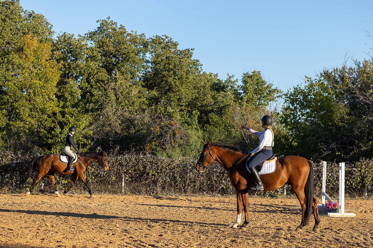 A horse trainer giving a beginner a lesson.